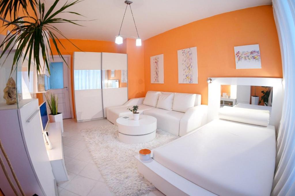 瓦尔纳Alex Botique的客厅配有白色家具和橙色墙壁