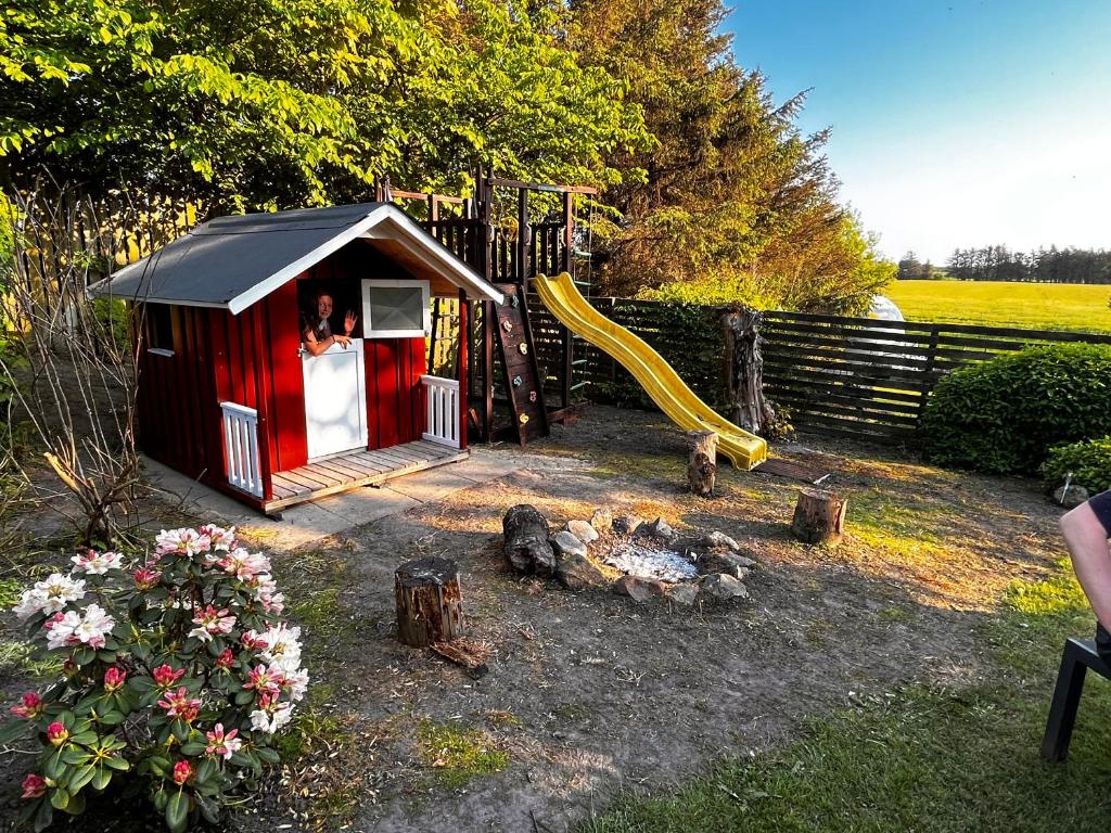 洛肯Løkken Farm Holiday的一个带滑梯的红色小游戏房