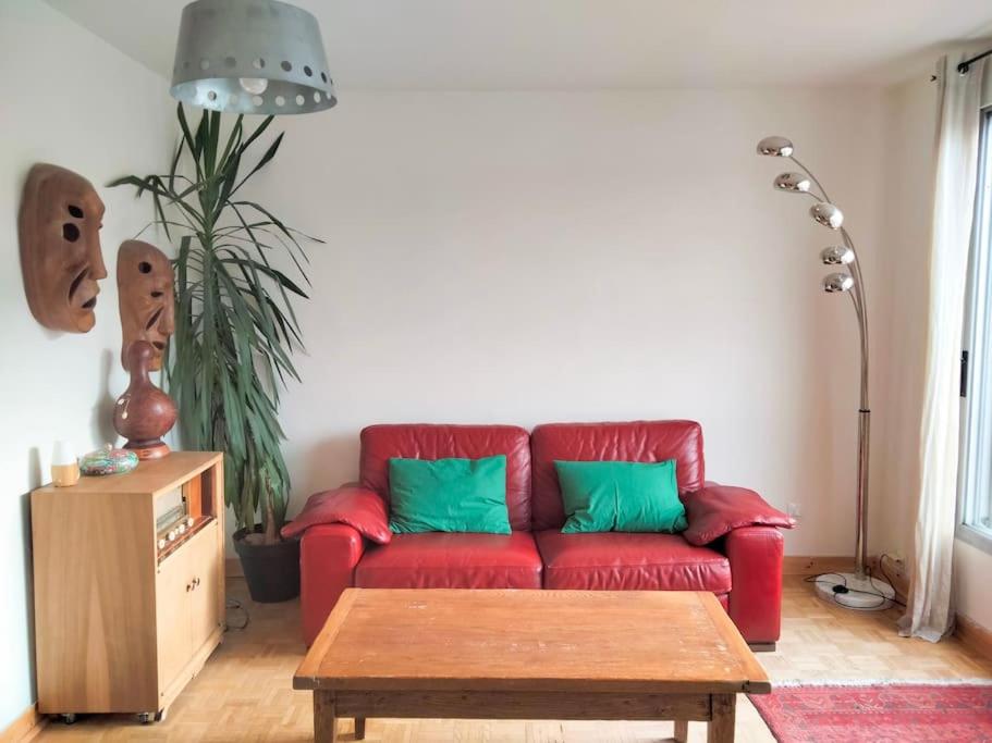 里昂Appartement familial 2 chambres的客厅配有带绿色枕头的红色沙发