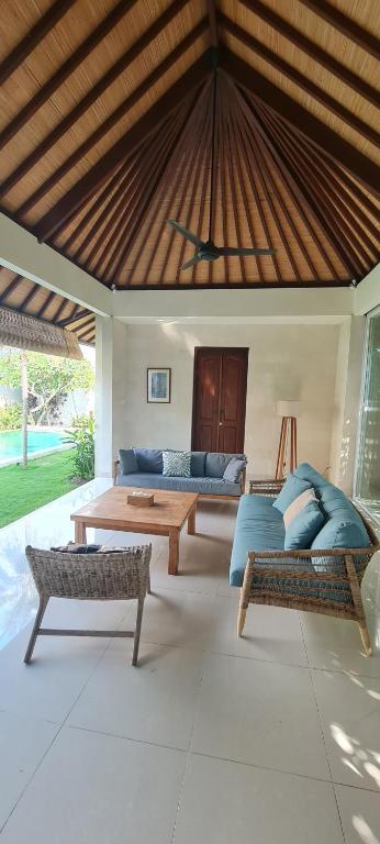 海神庙Villa Dimaya的客厅设有两张沙发和木制天花板