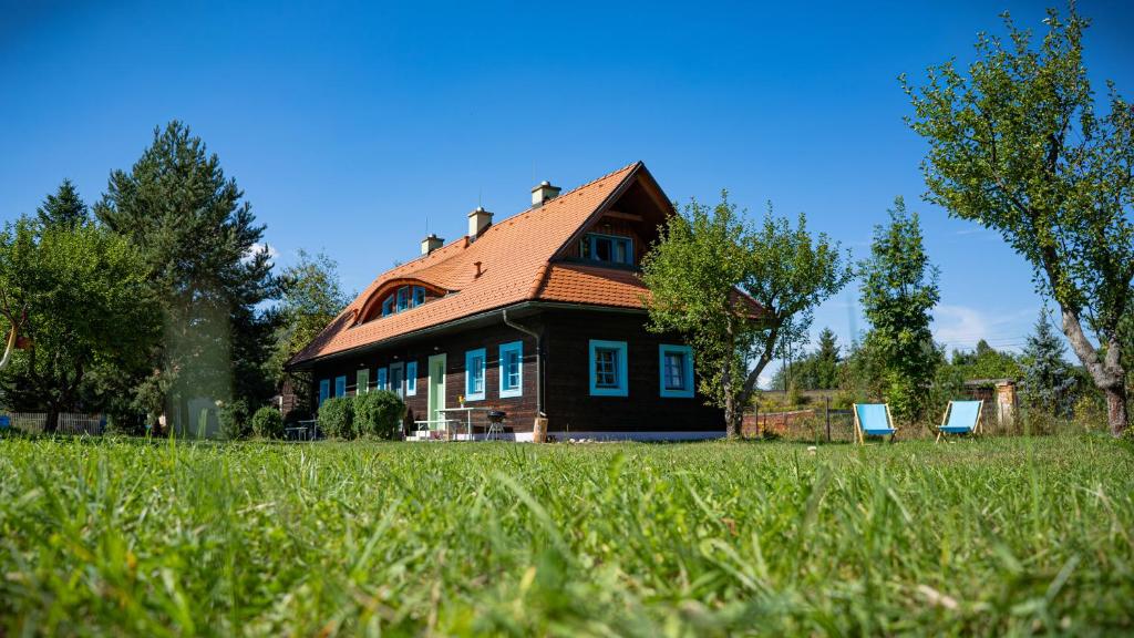 贝谢诺瓦Apartmánová chalupa v Dvore u maliara的前面有两把蓝色椅子的房子