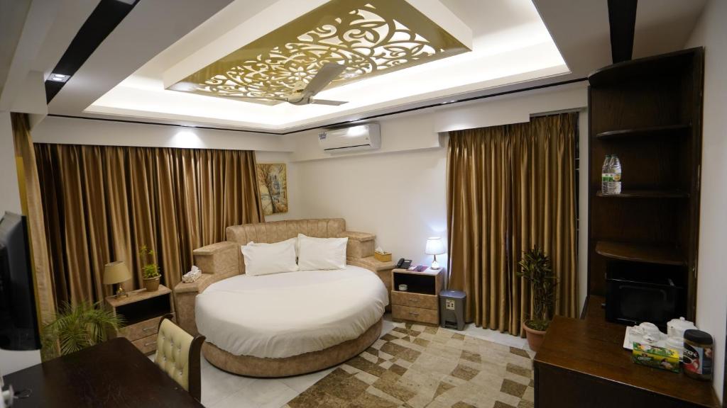 达卡Xpressmall Hotel near Dhaka Airport的一间卧室配有一张床、一张书桌和一台电视