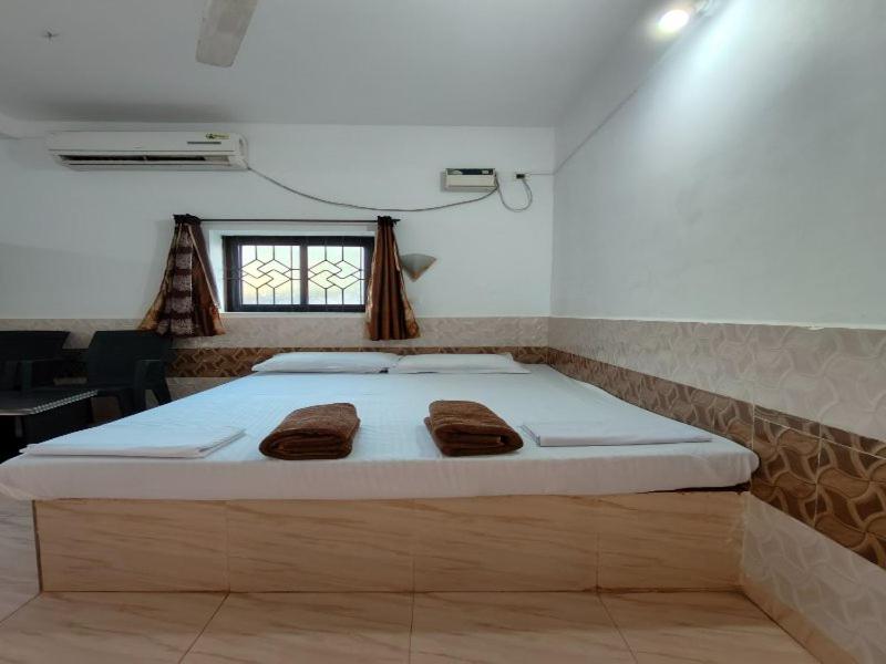 波戈马洛LEON HOME STAY的一间卧室配有一张床,上面有两条毛巾