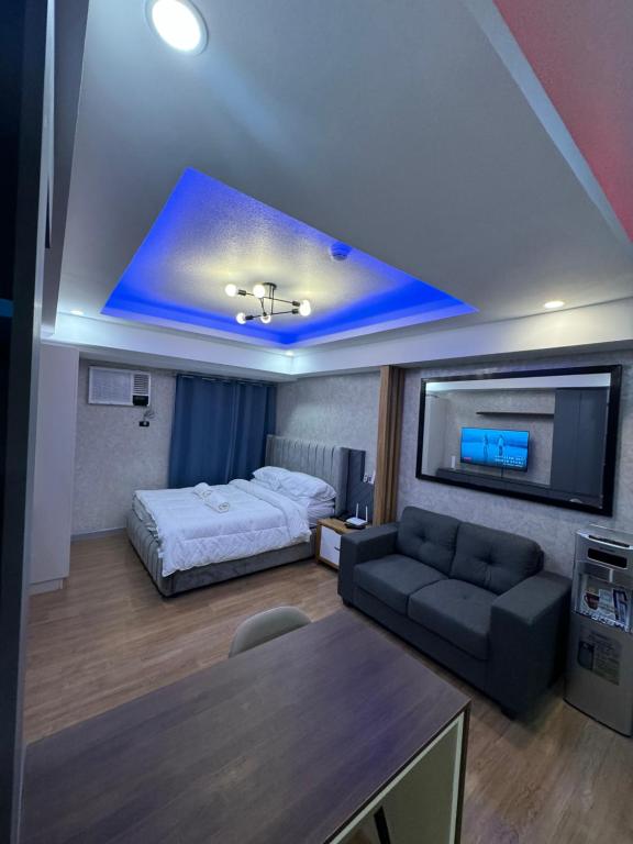 达沃市Abreeza Place T2 - 720的客房设有床、沙发和电视。
