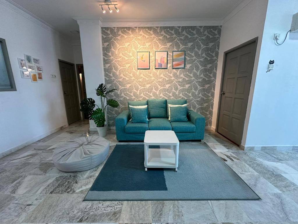 瓜埠Newly Renovated Seaview 3BR - 8Pax Baby Friendly的客厅配有蓝色的沙发和地毯。