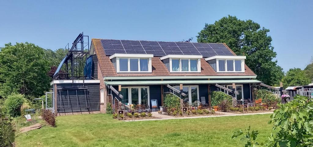 德克瓦克Huis over de dijk的屋顶上设有太阳能电池板的房子