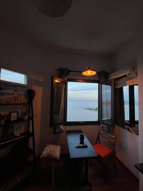 蒙得维的亚Hermoso apto frente al mar.的客房设有桌子和大窗户。