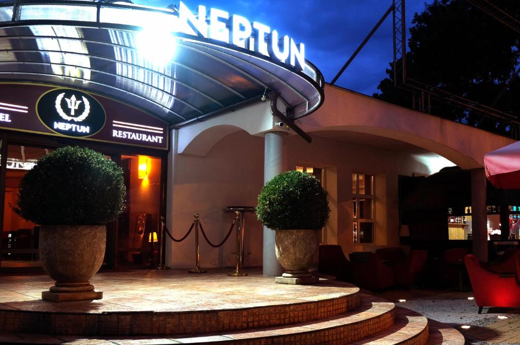 加茨比亚格拉Neptun Ψ的楼前有两株植物的餐厅