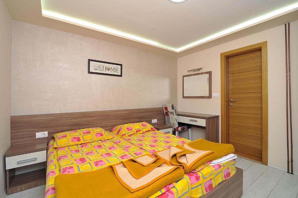 兹拉蒂博尔Vila Mina的一间卧室配有一张带黄色毯子的大床