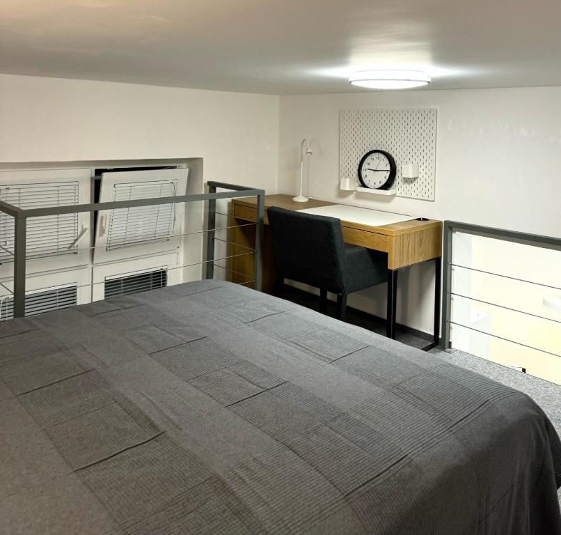 卢布尔雅那Elena Apartments的一间卧室配有一张床、一张书桌和一张书桌