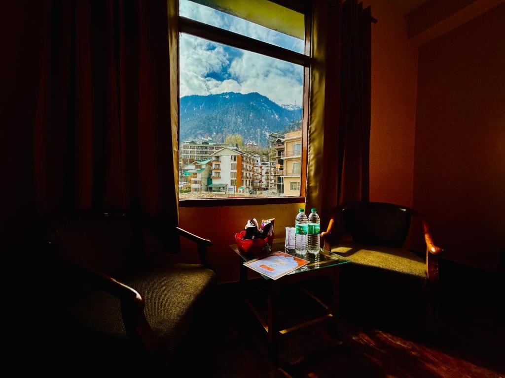 马拉里The Kalinga Resort Manali - Heaven In Mountains的客房设有桌子和享有美景的窗户。