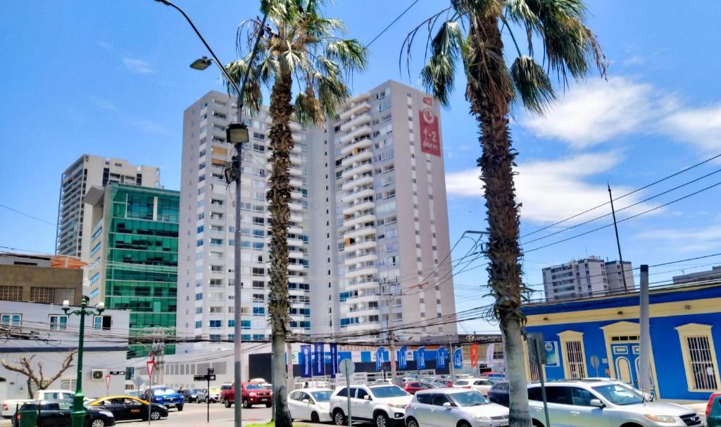 伊基克Céntrico y acogedor departamento equipado, incluye estacionamiento的两棵棕榈树,位于一座高楼