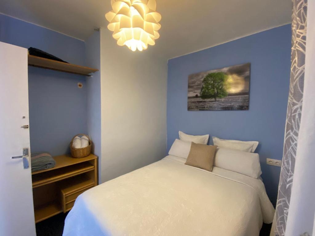 La RegudaLA CASA DE LAS HADAS的卧室配有白色的床和吊灯。