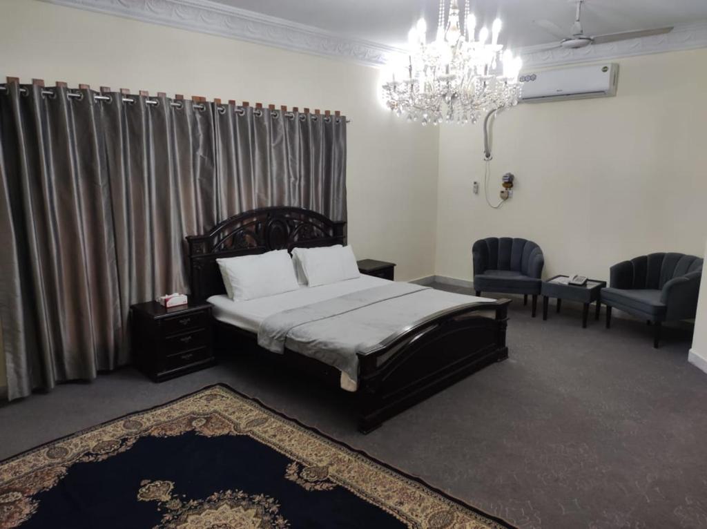 白沙瓦Askari Gold Crest的一间卧室配有一张床和一个吊灯