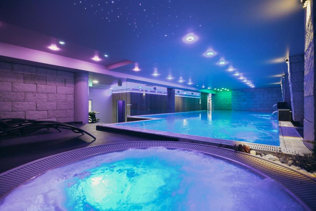 巴尼亚卢卡Wellness Spa Hotel Jola的一座带照明浴缸的大型游泳池
