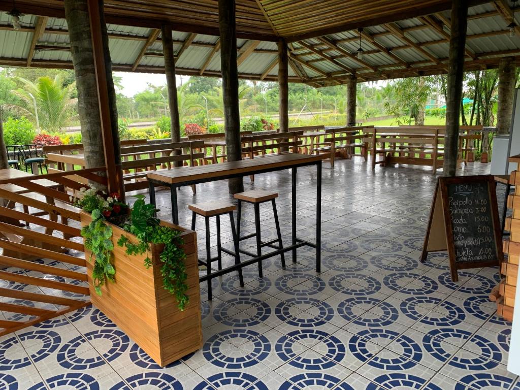 弗朗西斯科德奥雷利亚纳港Hostería Chambira的凉亭配有桌椅,位于瓷砖地板