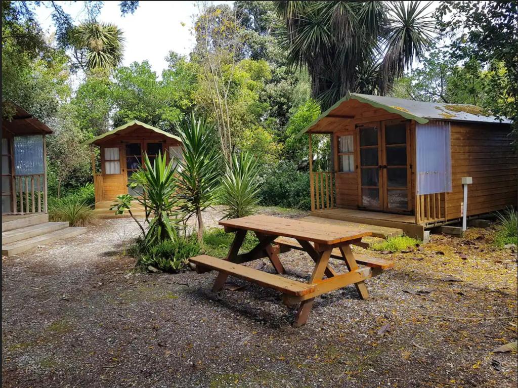 莫图伊卡Cozy Glamping Cabins的小屋前的木餐桌