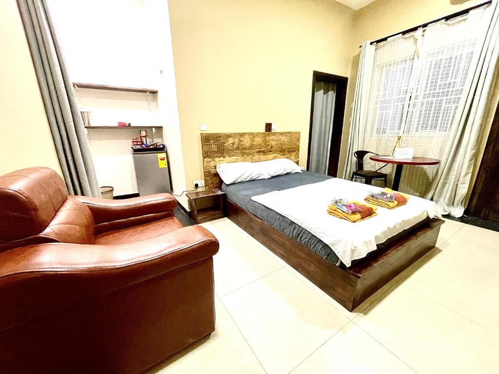阿克拉Accra Luxury Apartments At The Sanga Estates的一间卧室配有一张床、一张沙发和一把椅子