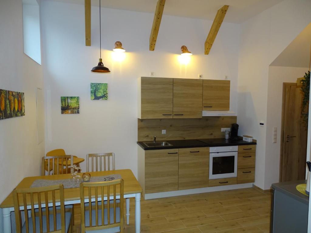 SimbachFerienwohnung Schusternagerl的厨房配有木制橱柜和桌椅