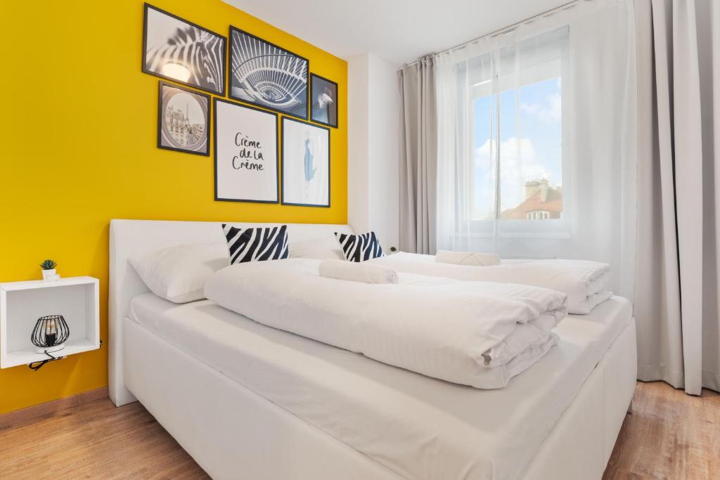 布拉迪斯拉发LAM Safari w Balcony, AC & Free parking的黄色墙壁的客房内的两张床