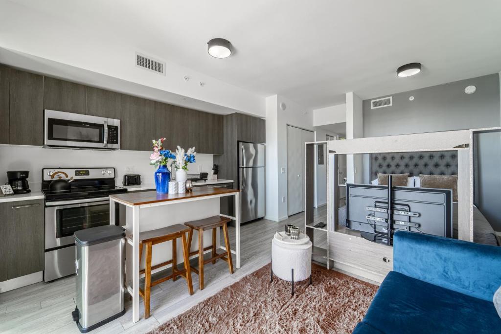 迈阿密Devereaux Miami Luxury One-Bedroom and Studios的厨房以及带蓝色沙发的客厅。
