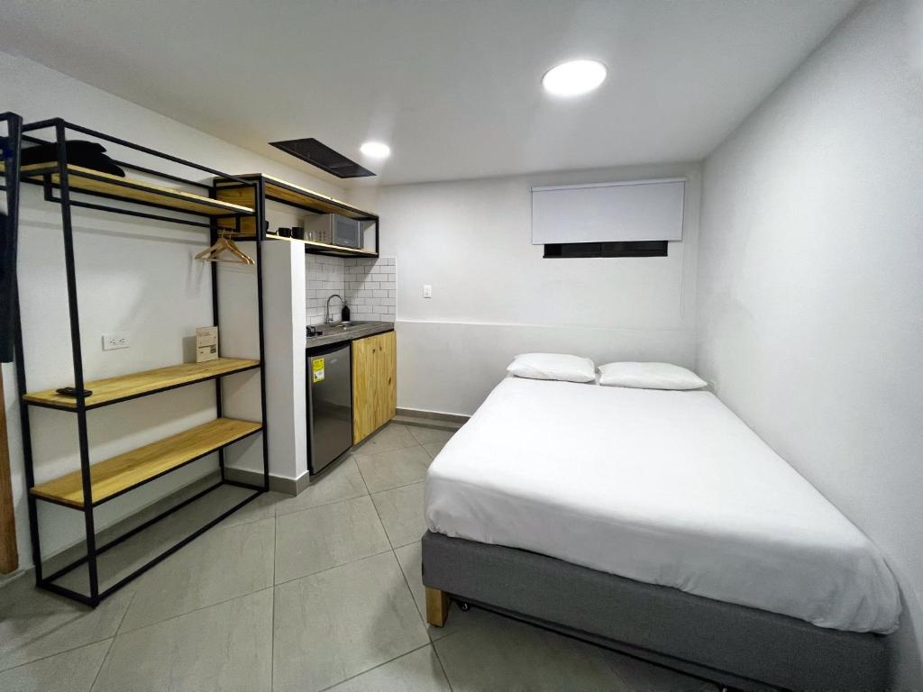 麦德林Casa hotel Los Laureles的一间带床的小卧室和一间厨房