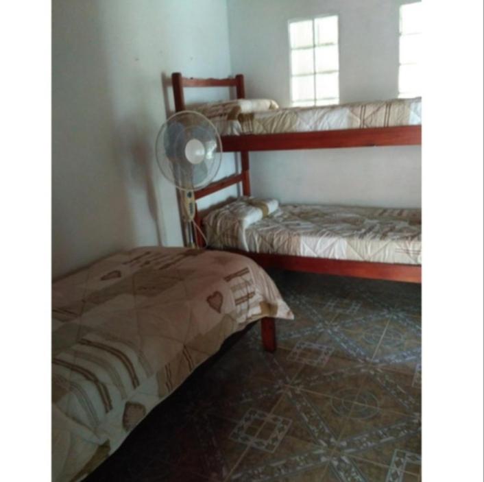 科斯塔阿苏尔Lo de Sandra的一间卧室设有两张双层床和风扇