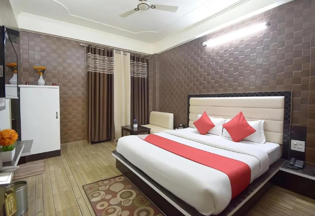 布巴内什瓦尔Goroomgo Om Sai Residency Bhubaneswar的一间卧室配有一张带红色枕头的大床