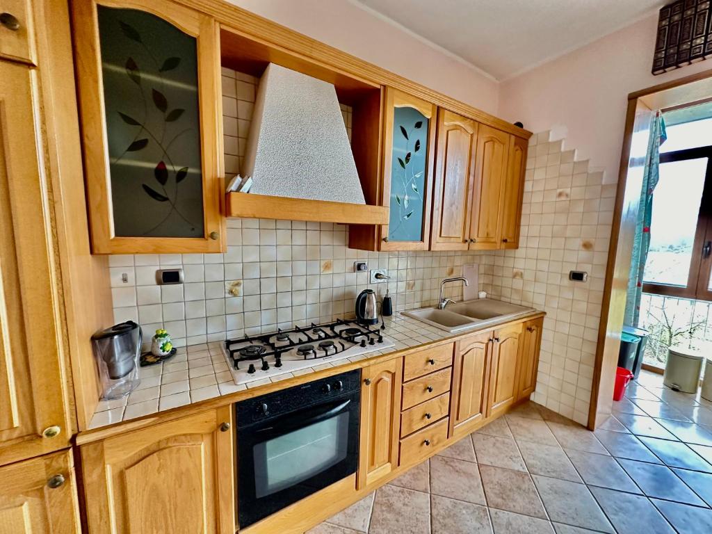 菲亚诺Finestra sulle Alpi e Golf的厨房配有木制橱柜和炉灶烤箱。