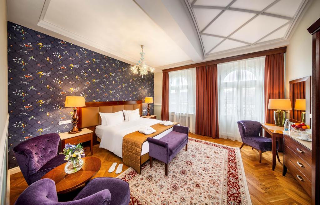 布拉格Esplanade Hotel Prague的酒店客房带一张床、一张桌子和椅子