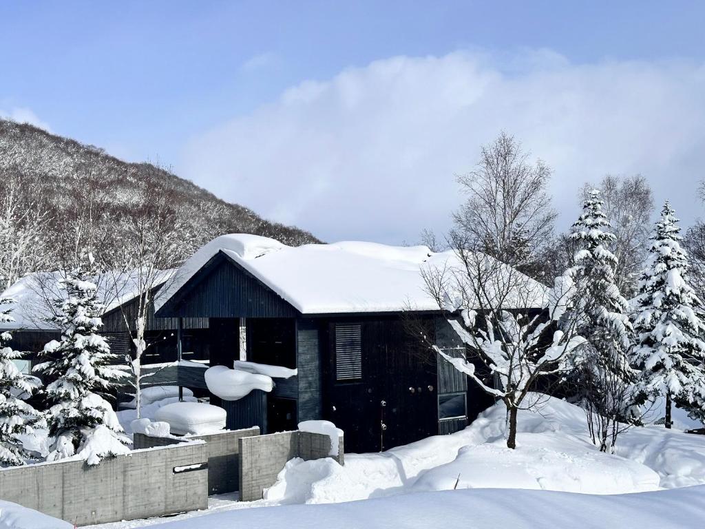 二世古新雪谷伊苏米克亚酒店的小屋,屋顶上和树上都有雪