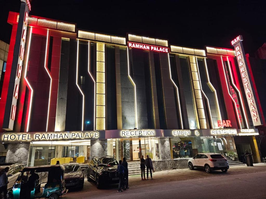 新德里Airport Hotel Ramhan Palace Mahipalpur的酒店大楼前面设有停车场