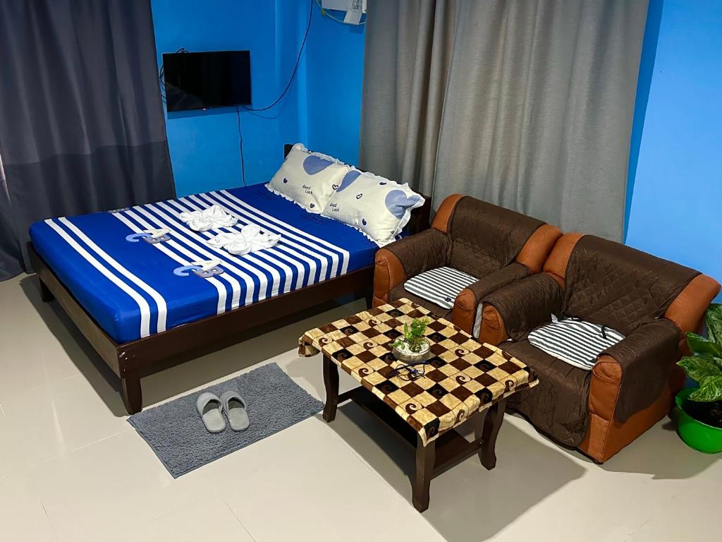 KabankalanRozay Travellers Inn的客房设有床、沙发和桌子。