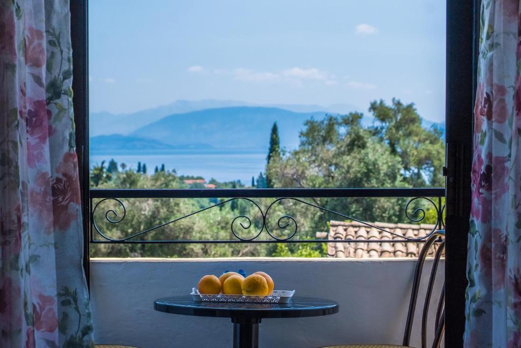 卡托克拉克阿纳Aggeliki apartments Dassia By Hotelius的阳台上的桌子上放着三个橙子,
