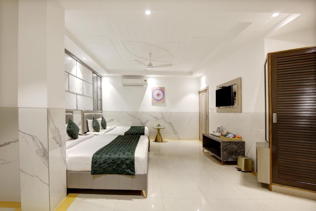 新德里Hotel Delhi 37 by Star Group NEAR DELHI AIRPORT的酒店客房,配有床和电视