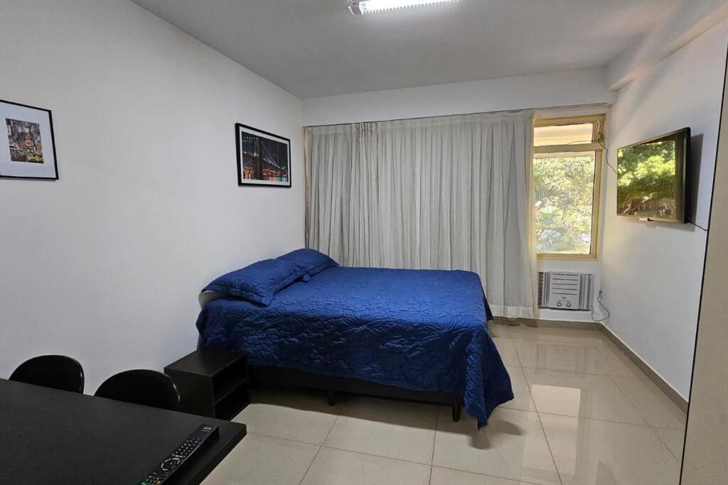 巴西利亚Conforto e Localização Perfeita的一间卧室设有蓝色的床和窗户。