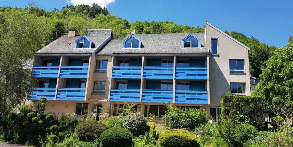 蒂耶扎克Le Castel du Cantal Groupe Village Fani的享有带蓝色阳台的大房子外部景色