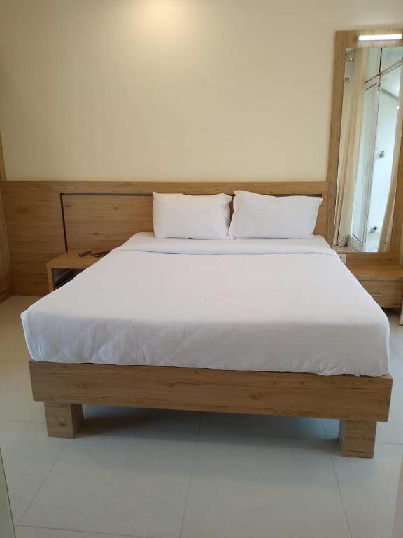 古鲁瓦尤尔Ambalath Ayesha Homes的一张带白色床单和枕头的床