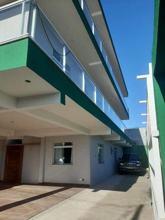 马蒂尼奥斯Pousada Belaisa的停车场位于带阳台的建筑的一侧
