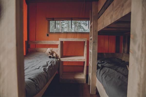 米洛Camping Saint-Lambert - Maeva的一间卧室设有两张双层床,床上放着一只狗。