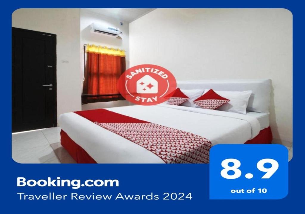 明古鲁省Super OYO 1678 Jati Exclusive Homestay的酒店客房,配有一张带标志的床