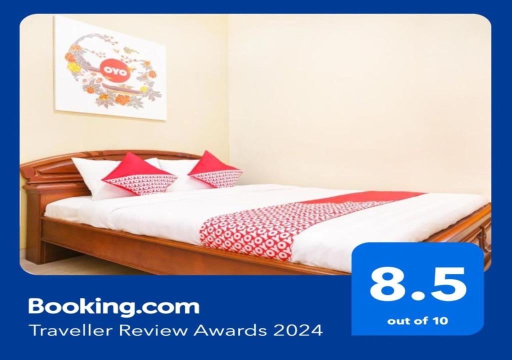 日惹OYO 90033 DeHome Family的一间卧室配有红色和白色枕头的床
