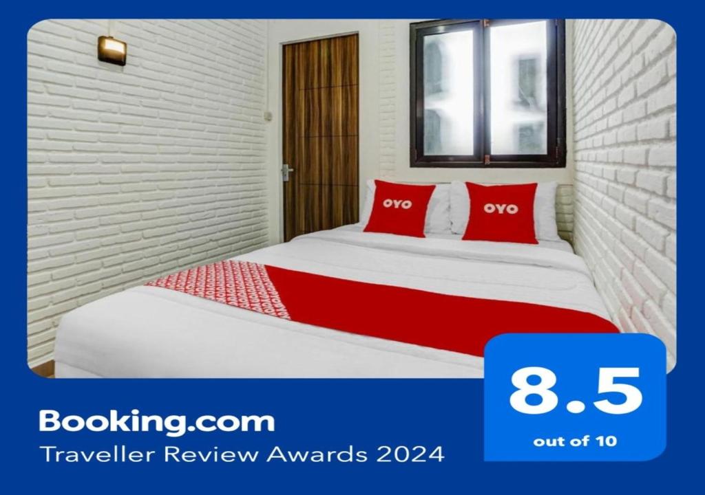 巴图Super OYO 90828 Ara Guest House的一间卧室配有红色枕头的床