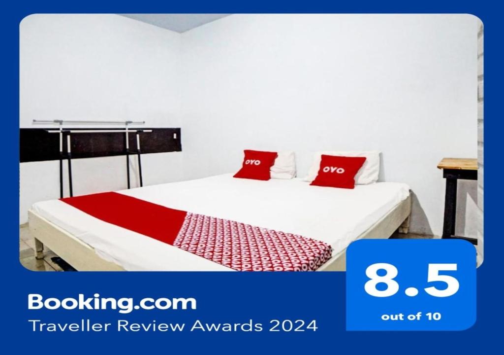 SunggalOYO 91959 La Khansa Homestay Syariah的一间卧室配有一张带红色枕头的床