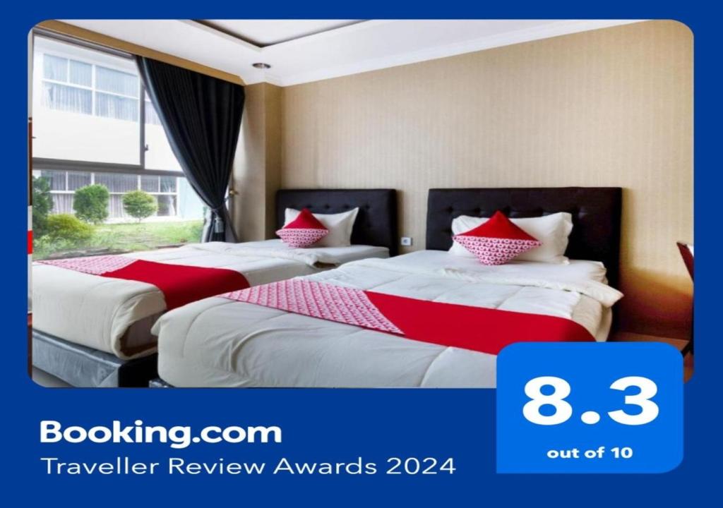 巨港Super OYO Collection O 3431 Hotel Alpha Bandara的两张位于酒店客房的床,配有红色和白色床单