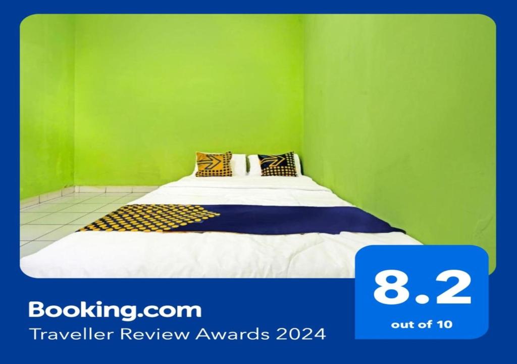 Cilimus 2SPOT ON 91325 Pondok Hijau Guest House Syariah的一间卧室设有一张带绿色墙壁的床