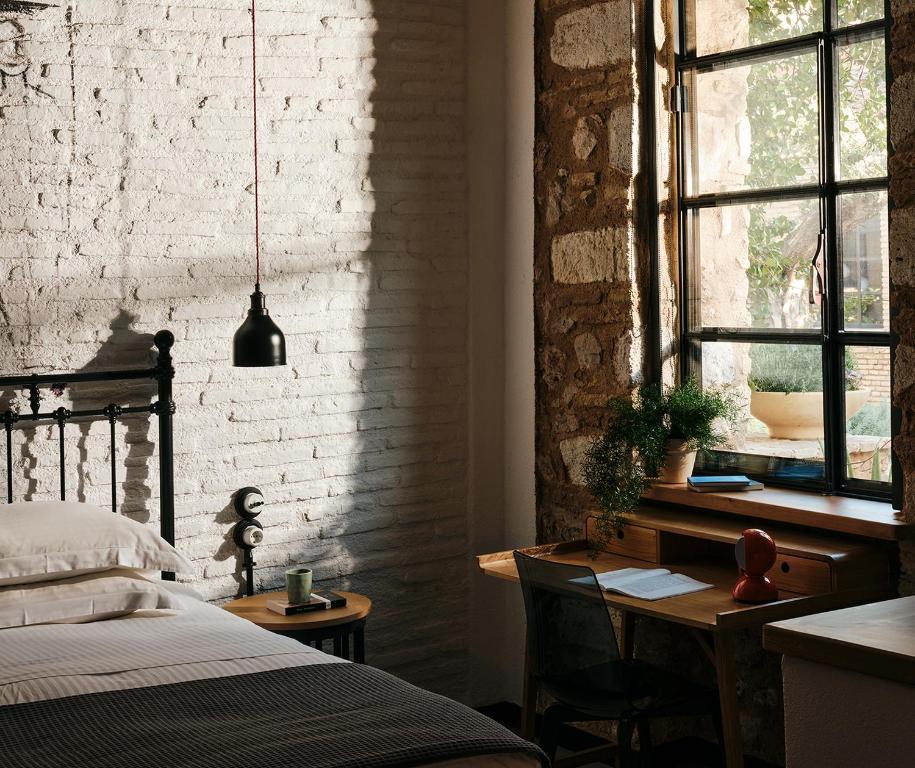雅典Not Hotel的一间卧室配有书桌、床和窗户。