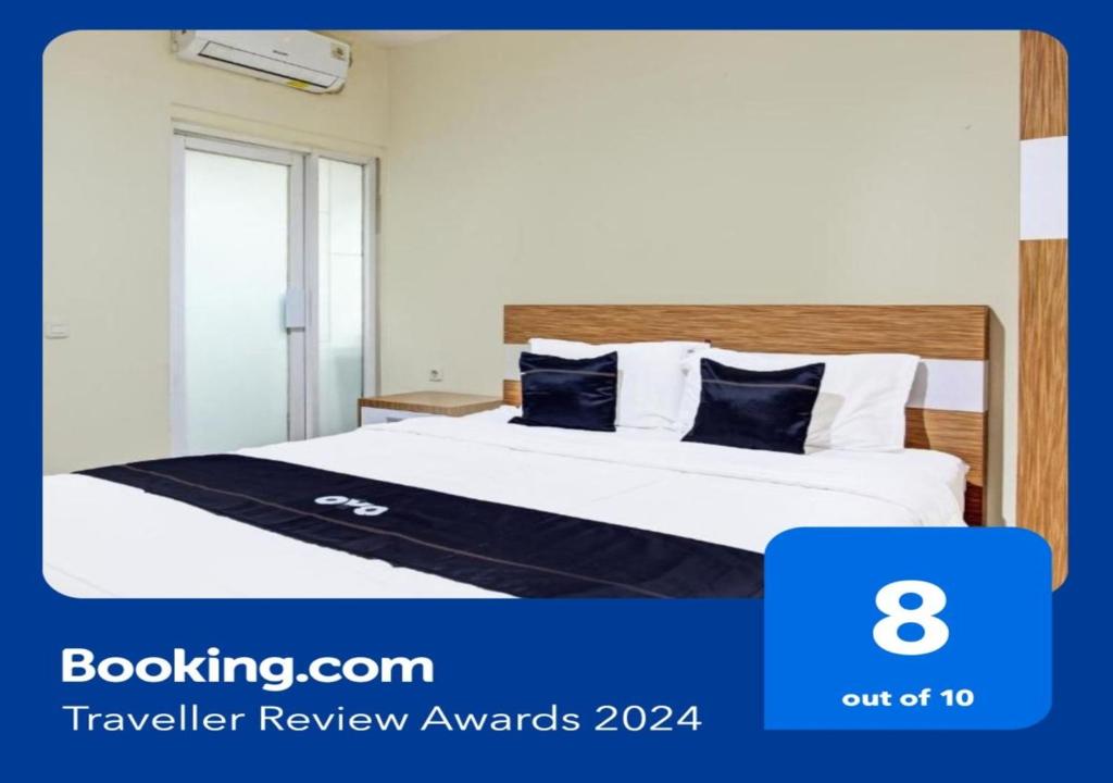 KalasanSuper OYO Collection O 90253 DHelomi的酒店客房配有带白色床单和蓝色枕头的床。
