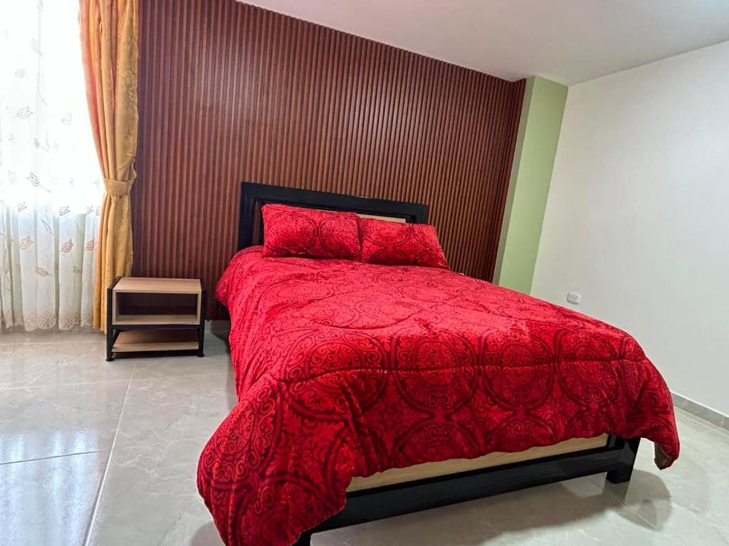 帕斯托Hotel Colonial House的一间卧室配有红色的棉被和红色的棉被