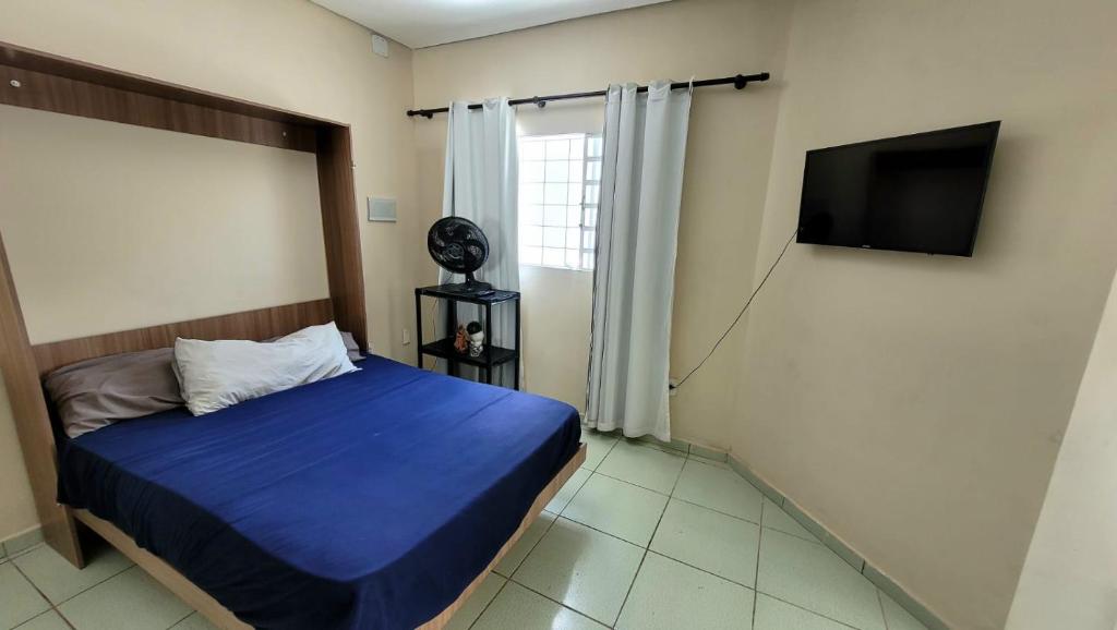 苏马雷Shekinah的一间卧室配有一张床和一台平面电视